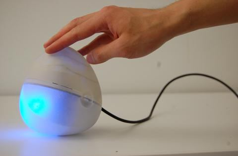 Hand holding a small wireless sensor